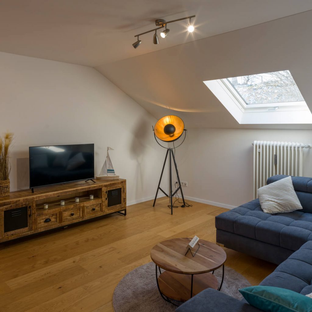 Ferienwohnung Aufhausen Starnberger See mit modernem Sofa und Tageslicht durch Dachfenster