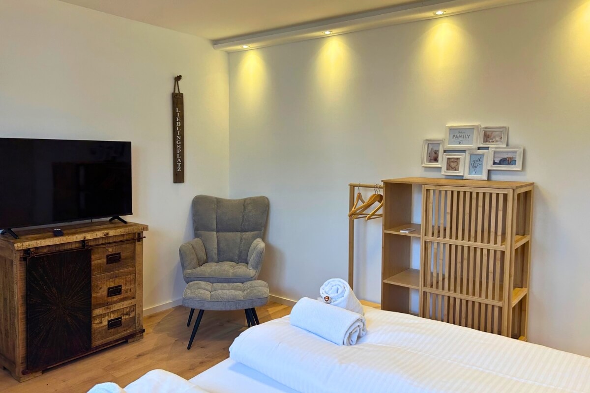 Schlafbereich mit TV und gemütlicher Sitzecke in der Ferienwohnung Aufhausen Klein